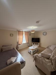 a bedroom with two beds and a couch and a tv at Culloden Stables 4 in Inverness