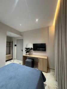 a bedroom with a bed and a desk with a television at Alesia's Guesthouse in Vlorë