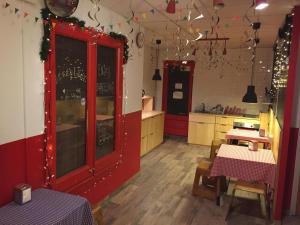 a kitchen with red cabinets and tables in a room at Buba House - Women Only Hostel in Barcelona