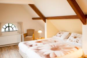 a bedroom with a large bed with flowers on it at Sint Nicolaashoeve in Nieuwveen