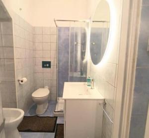 a bathroom with a sink and a toilet and a mirror at Un Raggio di Sole - a due passi dal mare in Montesilvano
