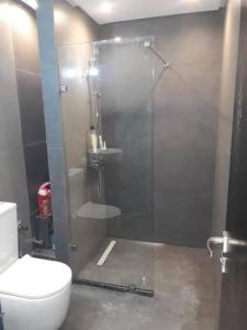 a bathroom with a glass shower with a toilet at Apartment Modern zeganrif in Segangane