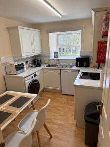 a kitchen with white appliances and a table and chairs at Culloden Stables 4 in Inverness