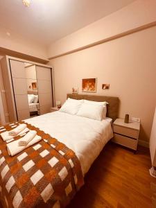 a bedroom with a large bed with a checkered blanket at EVA Premium Luxury Apartments - Limak Diamond Residence in Skopje