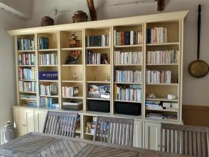 a large white book shelf filled with books at Domaine de Cadenne in Saint-Antonin