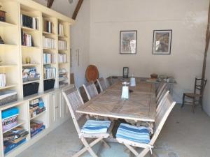 a dining room with a table and chairs and bookshelves at Domaine de Cadenne in Saint-Antonin