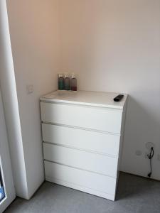 a white dresser with bottles on top of it at Studio mit Alpenblick und privaten Terrasse in Kleinweil
