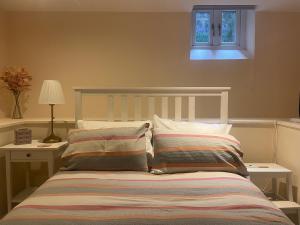 a bedroom with a bed with two pillows and a window at Trailside in Headingley in Leeds