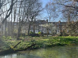 a large house with a pond in front of it at Trailside in Headingley in Leeds