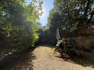 a table and an umbrella sitting on a gravel path at La Casa di Ornella in Rome