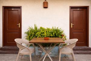 a wooden table with two chairs and two doors at Dahab Hostel in Cairo