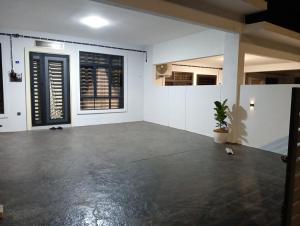 an empty room with a concrete floor and windows at HOMESTAY IMPIAN AYER MOLEK MUSLYM only in Malacca
