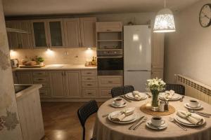 a kitchen with a table with chairs and a white refrigerator at Dąbrowski in Nadarzyn