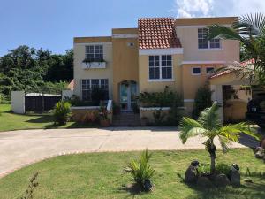 a house with a palm tree in front of a driveway at A Private Paradise by the Rainforest in Luquillo