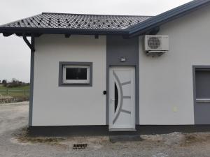 a white building with a door and a window at Studio Angelina in Prestranek