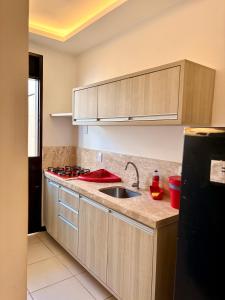 a kitchen with a sink and a stove at Hotel Natal Ponta Negra Sun in Natal