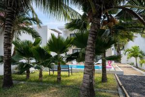 a resort with palm trees and a swimming pool at Chalet des Roses in Grand-Baie