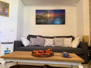 a living room with a couch and a bowl of fruit on a table at La Casa di Ornella in Rome
