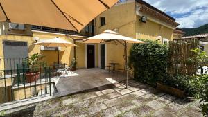 a patio with umbrellas and chairs and a building at Suite Casa Santicelli Maratea in Maratea
