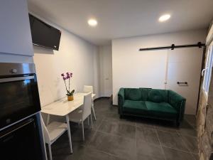 a living room with a green couch and a table at Mabel House Suites in Mijares