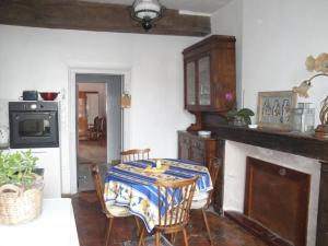 a dining room with a table and a fireplace at Appartement des Vieilles Halles in Fère-en-Tardenois