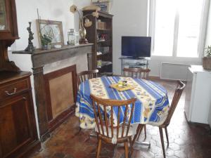 a dining room with a table and chairs and a television at Appartement des Vieilles Halles in Fère-en-Tardenois