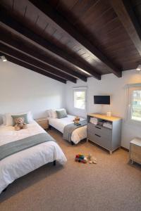 a bedroom with two beds and a desk with a television at Casa en Vilallobent Cerdanya ideal familias by CalQuerol in Vilallovent