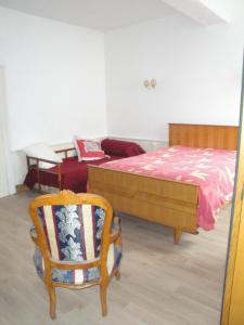 a bedroom with a bed and a chair and a couch at Appartement des Vieilles Halles in Fère-en-Tardenois