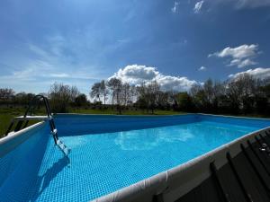 a large swimming pool on a balcony with the sky at Gîtes de la Bernière in Brûlain
