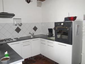 a kitchen with white cabinets and a white refrigerator at Appartement des Vieilles Halles in Fère-en-Tardenois +2 photos