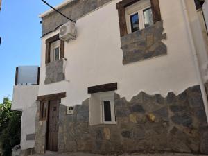 a building with two windows and a stone wall at Mabel House Suites in Mijares