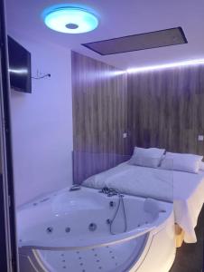 a room with a bath tub and a bed at Mabel House Suites in Mijares