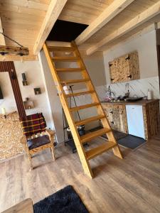a wooden staircase in a room with a kitchen at Mountains story in Bistrica Lipovska