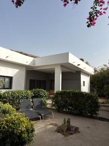 two chairs sitting in front of a house at Chez Sira in Warang