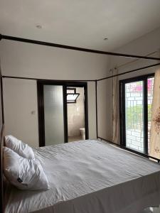 a bedroom with a large bed with a large window at Chez Sira in Warang