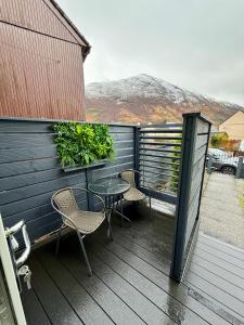 a patio with two chairs and a table on a deck at The NOOK in Kinlochleven