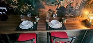 a wooden table with plates and wine glasses on it at The NOOK in Kinlochleven