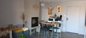 a living room with a table and a fireplace at Au jeu de mots, chambre d'hôtes proche Poligny in Barretaine