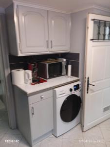 a small kitchen with a microwave and a washer at Large Studio in a cozy house in Ormesson-sur-Marne