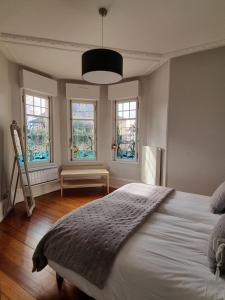 a bedroom with a large white bed with windows at L'Ourson in Colmar