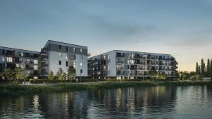 two apartment buildings next to a body of water at LUXURY Portovo in Gdańsk