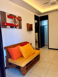 a couch with orange and orange pillows in a room at Hotel Natal Ponta Negra Sun in Natal +18 photos