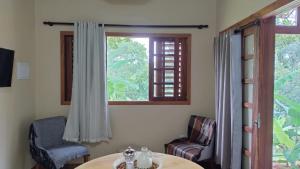 a room with a table and chairs and a window at Recanto da Julie in Mulungu
