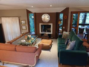 a living room with two couches and a table at Refúgio da Serra in Campos do Jordão