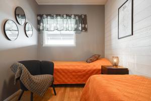 a bedroom with two beds and a chair and a window at Rukan Houkutus in Ruka