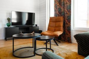 a living room with a tv and a chair at Rukan Houkutus in Ruka