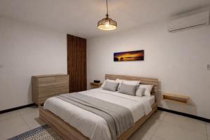 a bedroom with a large bed and a chandelier at Chalet des Roses in Grand-Baie +16 photos