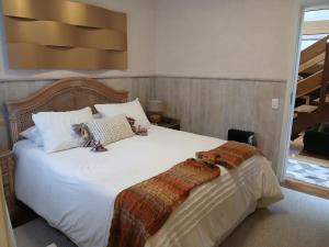 a bedroom with a large bed with white sheets at Refúgio da Serra in Campos do Jordão