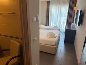 a hotel room with two beds and a window at Hotel Porto Azzurro in Sirmione