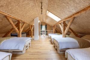 a row of beds in a room with wooden floors at Srčkova Koča in Kočevje